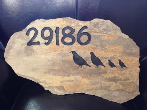 Multi colored sandstone engraved with quail family